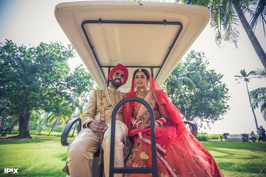 bride and groom red lehenga beautiful Sikh wedding in Grand Hyatt Goa couple ride in golf cart