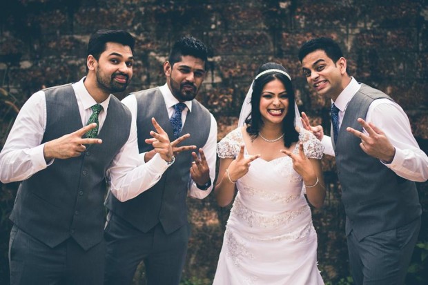 Indian Christian bride laughing with the groomsmen