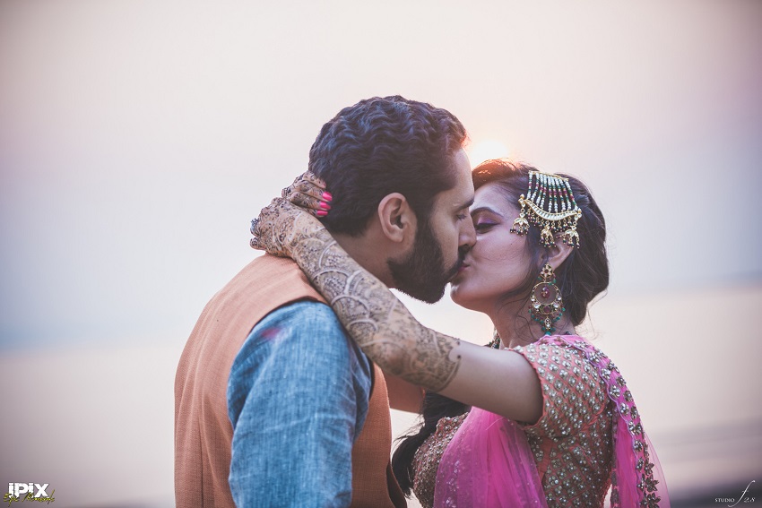 bride and groom kiss on beach in Goa Sikh wedding